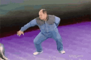 a bald man is dancing on a purple surface .