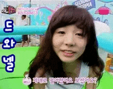 a girl with long hair is making a funny face in front of a green pool .