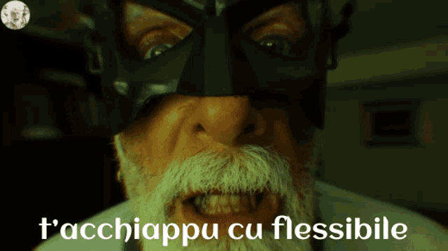 a man with a beard wearing a black mask and the words t'acchiappu cu flessibile