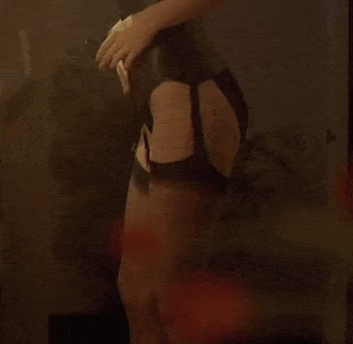 a woman in a black corset is looking in the mirror