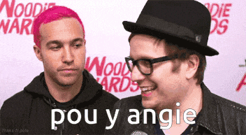 two men are standing next to each other and one of them is wearing glasses and a hat
