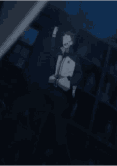 a man is standing in a dark room with his arms up in the air .