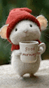 a stuffed animal mouse wearing a red hat and scarf is holding a cup of coffee .