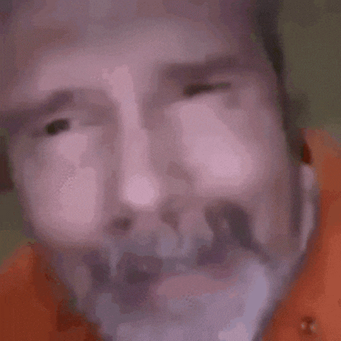 a close up of a man 's face with a beard and a surprised look on his face .