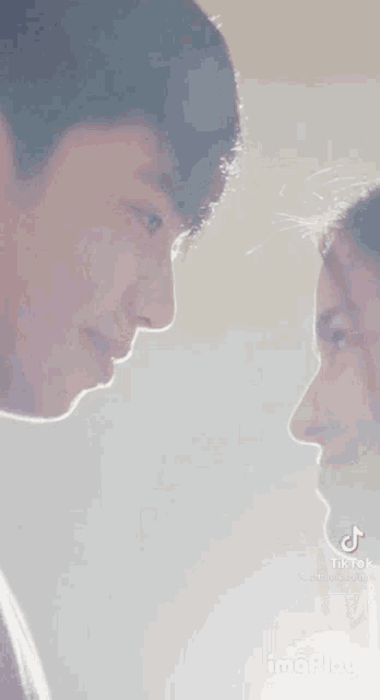 a man and a woman are looking at each other 's faces .