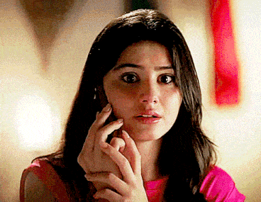 a woman in a pink shirt is talking on a phone