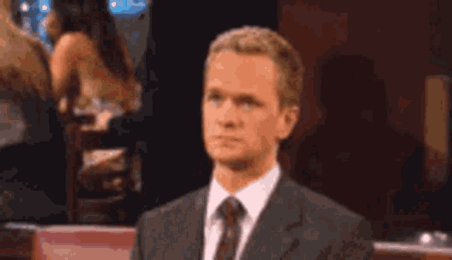 a man in a suit and tie is making a funny face .