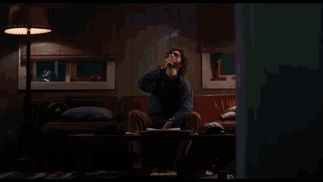 a man sits on a red couch in a living room