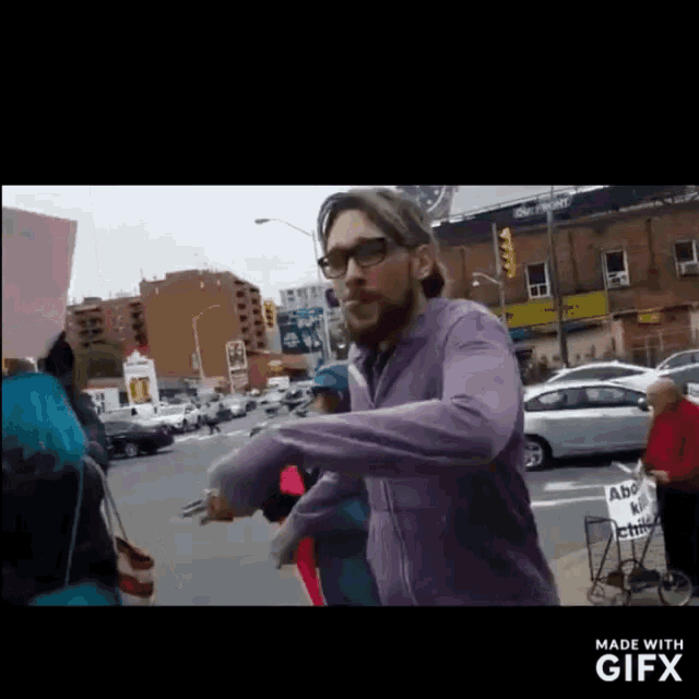 a man in a purple jacket stands in front of a sign that says abolish