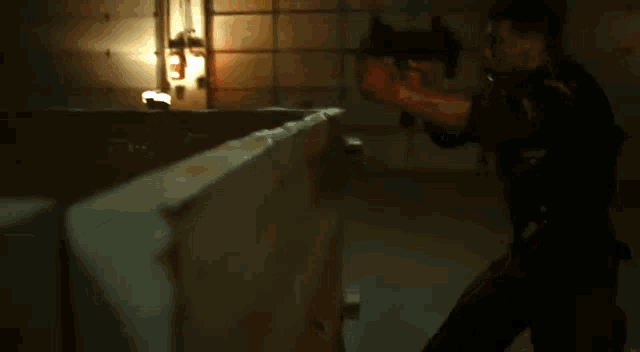 a man is holding a gun with a flame coming out of it .