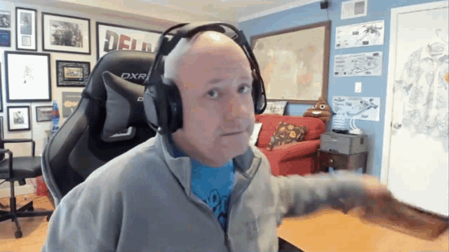 a man wearing headphones in a room with a sign on the wall that says delu