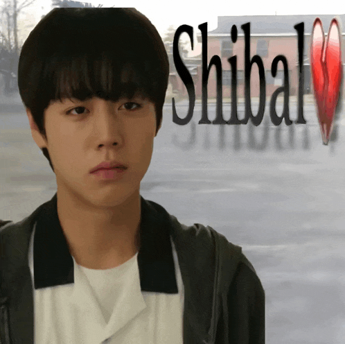 a young man stands in front of a sign that says shibal on it