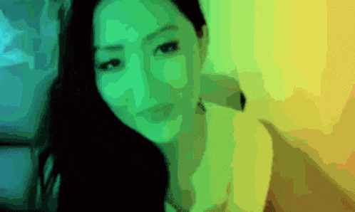 a blurry picture of a woman 's face with green and yellow highlights