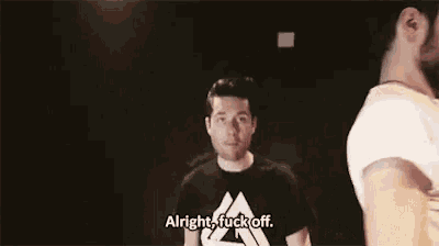 a man in a black shirt is saying alright fuck off