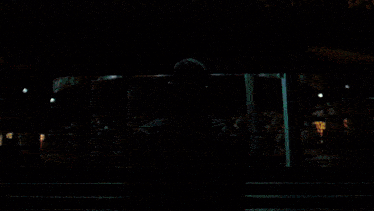 a man is looking out a window at a bus that says first on the side