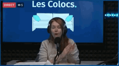 a woman wearing headphones stands in front of a microphone in front of a screen that says les colocs