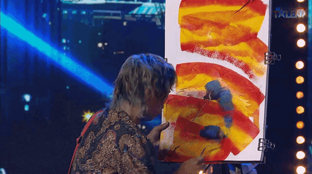 a man is painting on a canvas with the word talent on the bottom