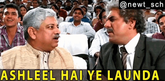 two men are talking in front of a crowd with the words ashleel hai ye launda above them