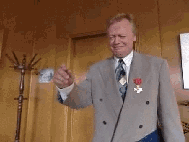 a man in a suit and tie with a medal around his neck .