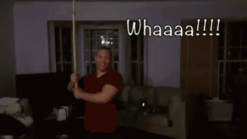 a man in a red shirt is holding two lightsabers and the words whaaaa are above him