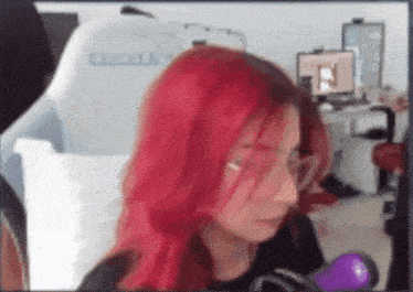 a woman with red hair is sitting in front of a computer screen .