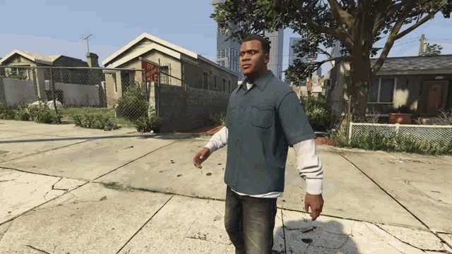 a man in a blue shirt is walking down the sidewalk