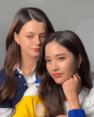two women standing next to each other with one wearing a shirt that says r on it