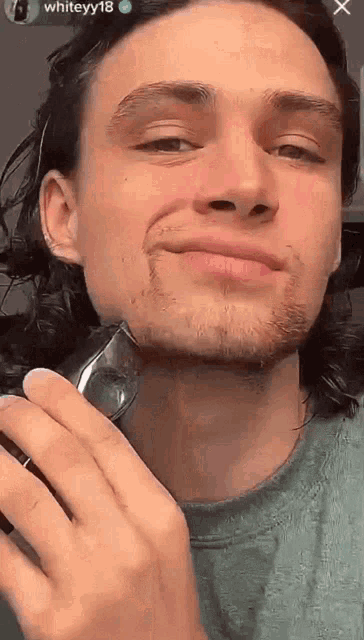 a man is shaving his face with the name whiteyy18 at the bottom
