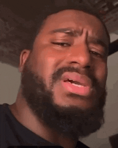 a close up of a man with a beard making a funny face with his mouth open .