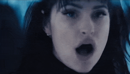 a close up of a woman 's face with her mouth open and her eyes closed .