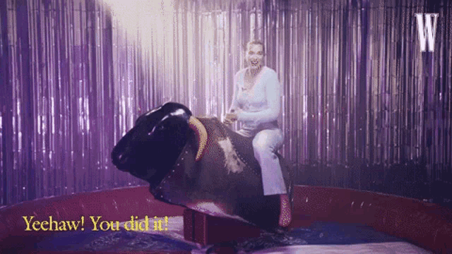 a woman is riding a bull in a rodeo and says yeehaw