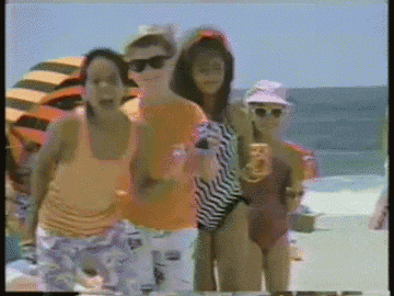 a group of people are standing on a beach holding drinks