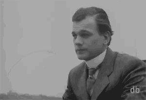 a black and white photo of a man in a suit and tie with the letters db on the bottom