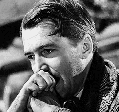 a black and white photo of a man with his hand on his chin