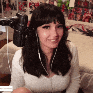 a woman wearing headphones is sitting in front of a microphone and smiling .