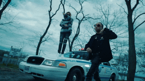 a man standing on top of a police car