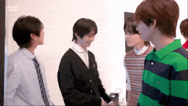 a group of young men are standing next to each other with ahof in the corner