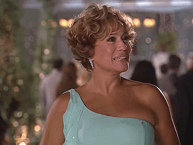 a woman in a blue one shoulder dress is smiling and looking at the camera .