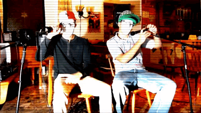 a man in a green hat is playing a flute while another man sings into a microphone