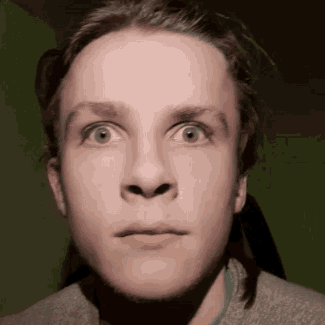 a close up of a young man 's face with a green background