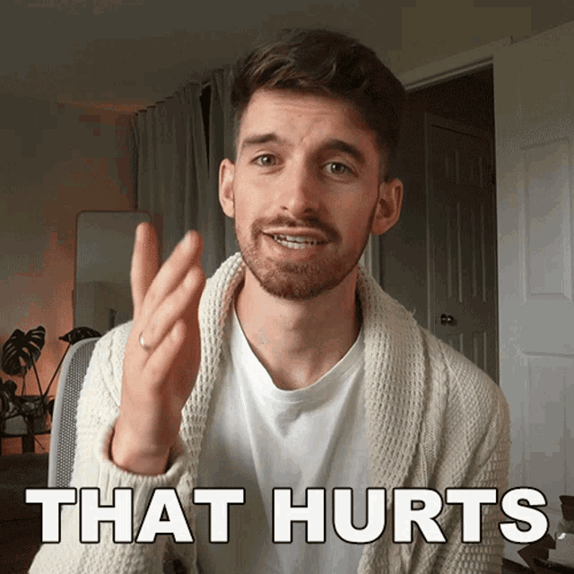 a man with a beard says that hurts with his hand