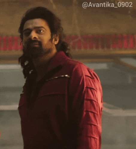 a man with long hair and a beard is wearing a red jacket with the hashtag @avantika_0902