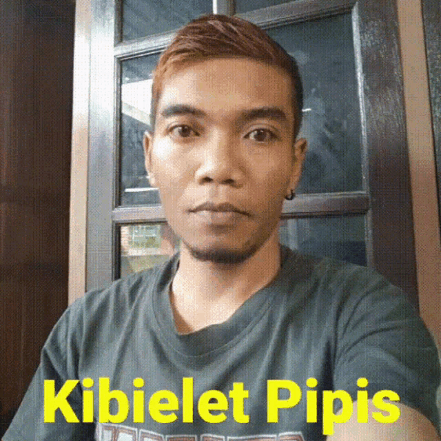 a man wearing a t-shirt that says kibielet pipis takes a selfie