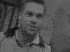 a black and white photo of two men standing next to each other in a doorway .