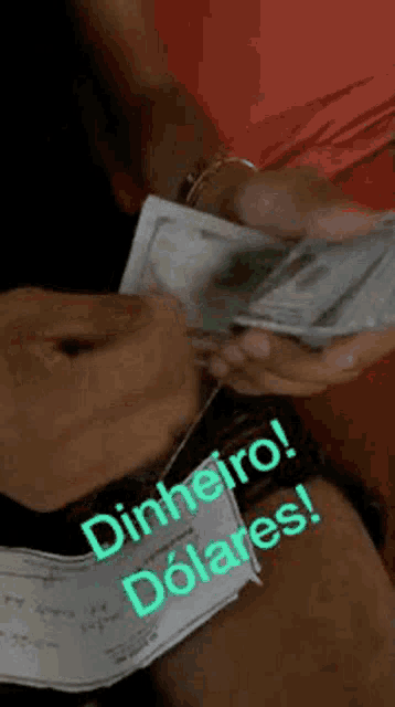 a person is holding a bunch of money in their hands and signing a check .