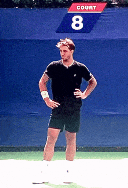 a man stands on a tennis court with a sign that says court 8