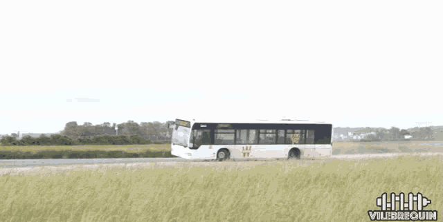 a white bus is driving down a road with a sign that says vilebouin