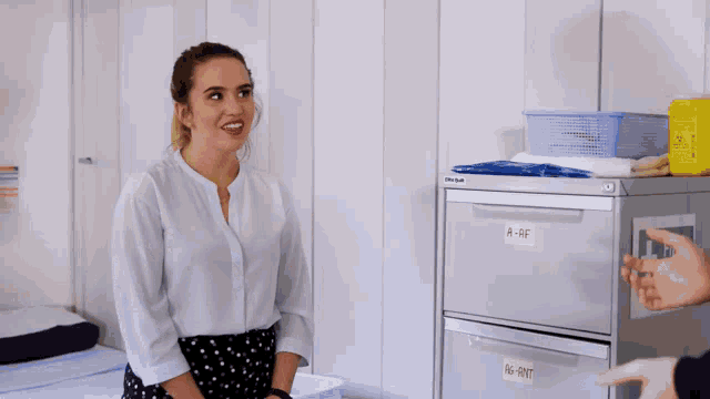 a woman is standing in front of a first aid kit