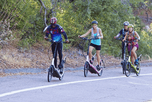 a group of people riding bikes on a road with one wearing a shirt that says ' r.i.p. '