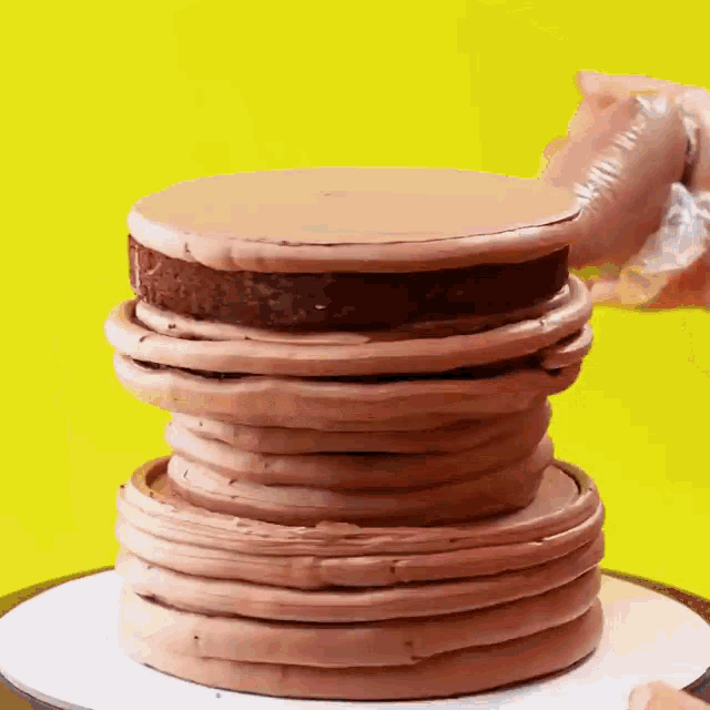 a stack of chocolate pancakes on top of each other with a yellow background